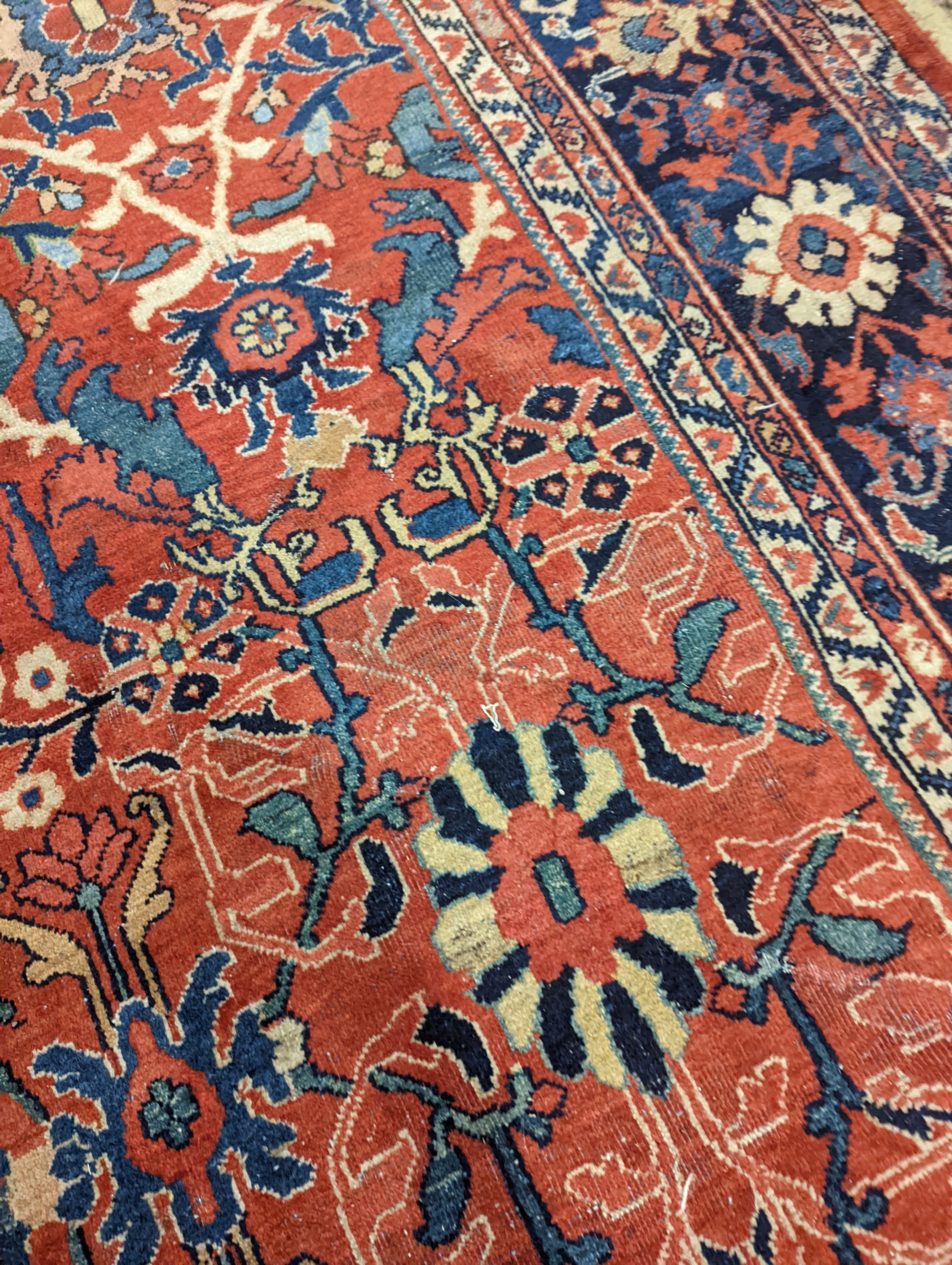 A Heriz brick red ground carpet, 364 x 280cm